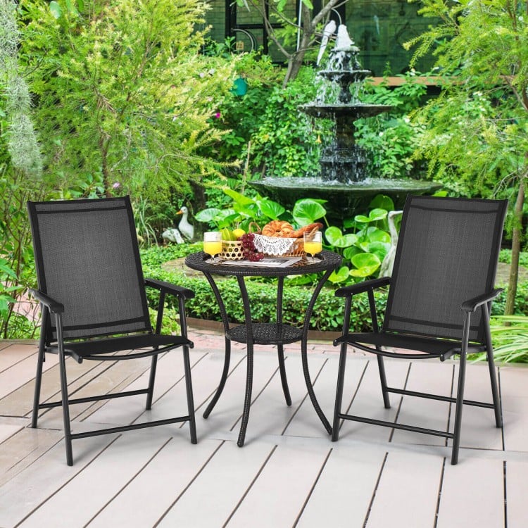 Set of 2 black outdoor patio folding chairs with ergonomic armrests, placed in a garden setting for relaxation.